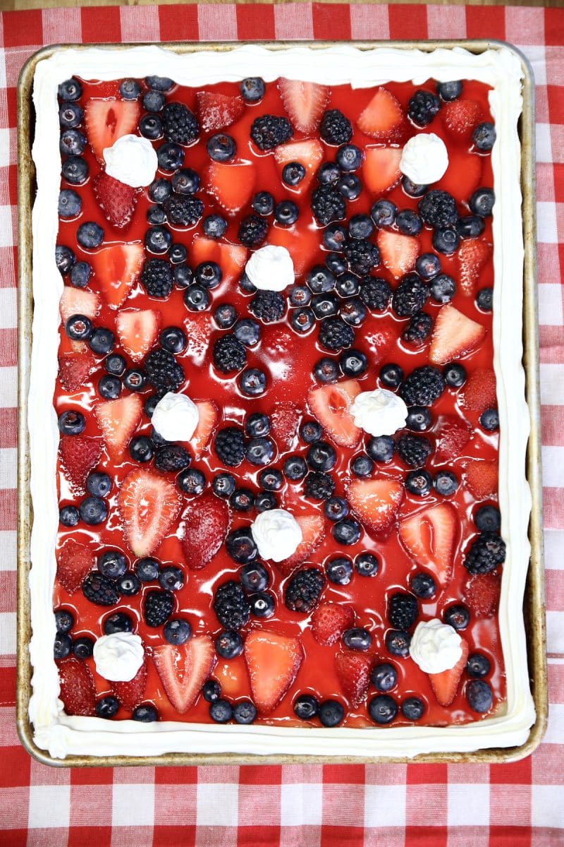 Mixed Berry Slab Pie with cool whip garnish.