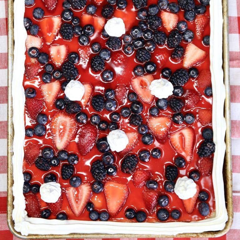Berry slab pie with jello glaze, whipped cream garnish.