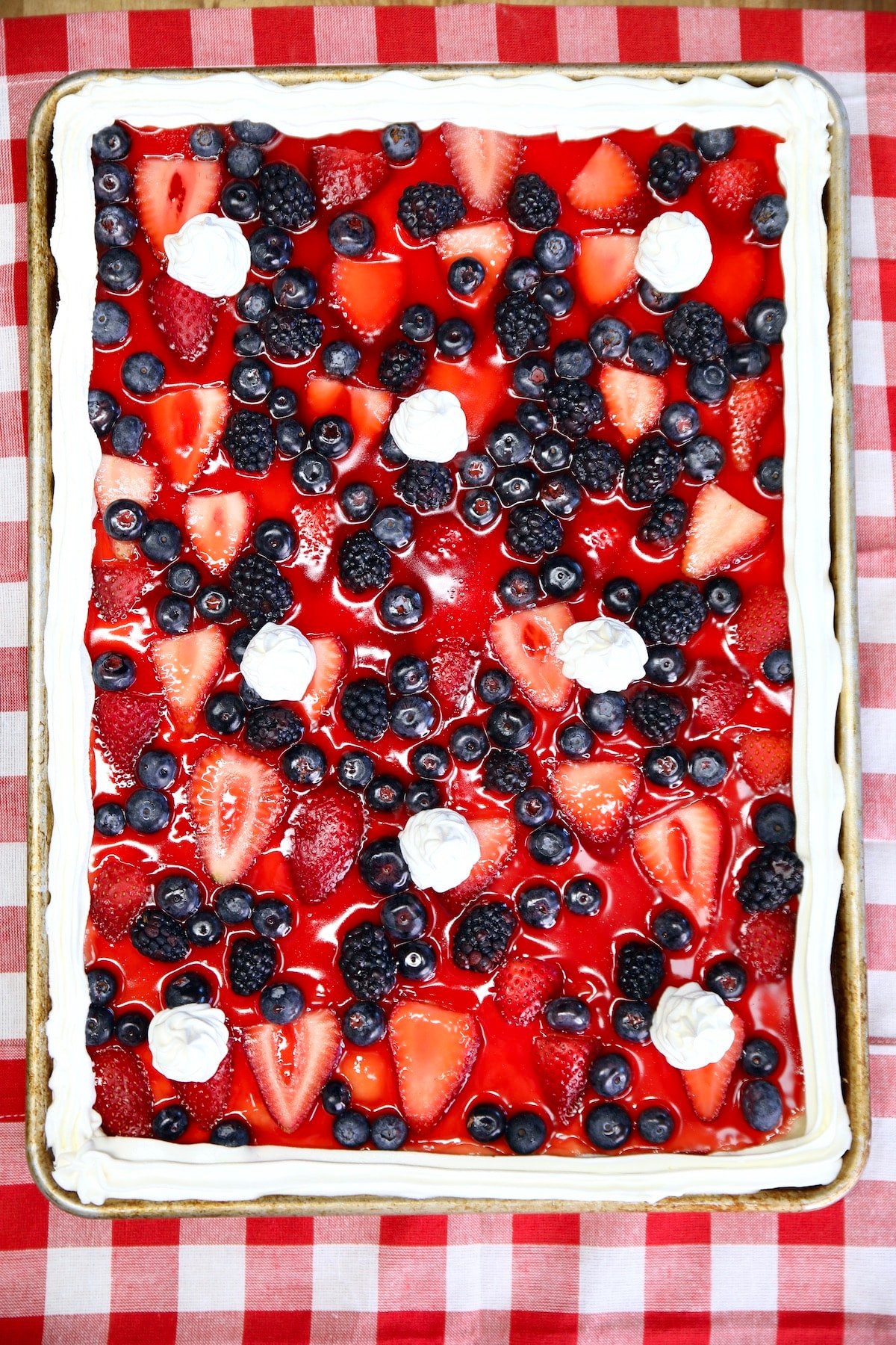 Mixed Berry Slab Pie with cool whip garnish.