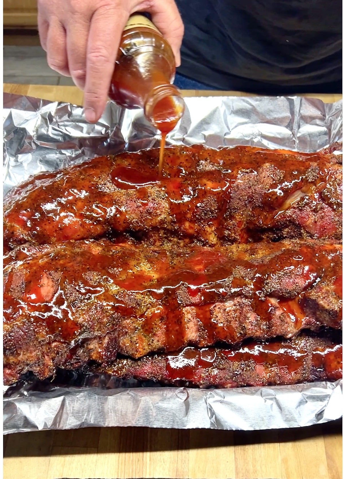 Pouring bbq sauce on ribs. 