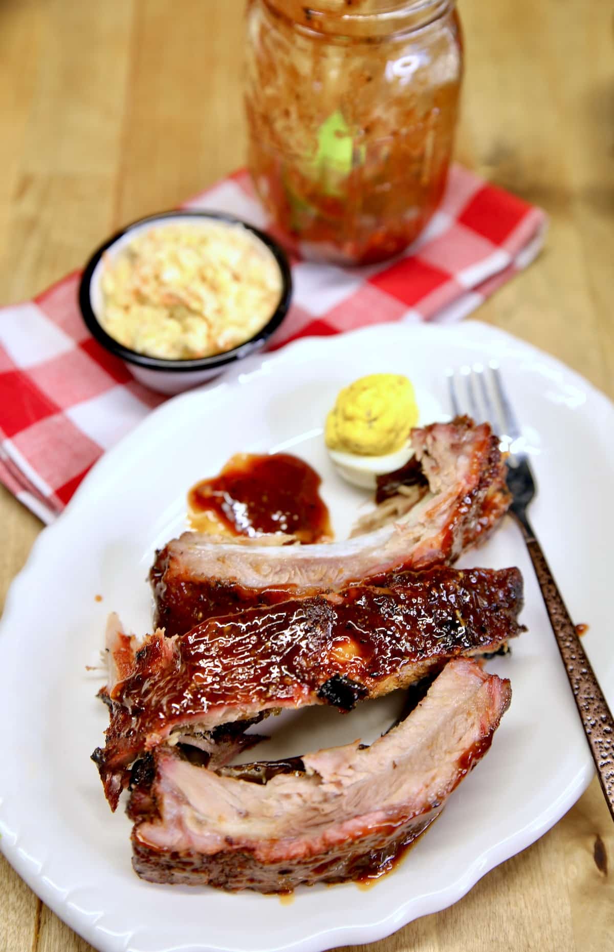 Plate with baby back ribs, deviled egg.