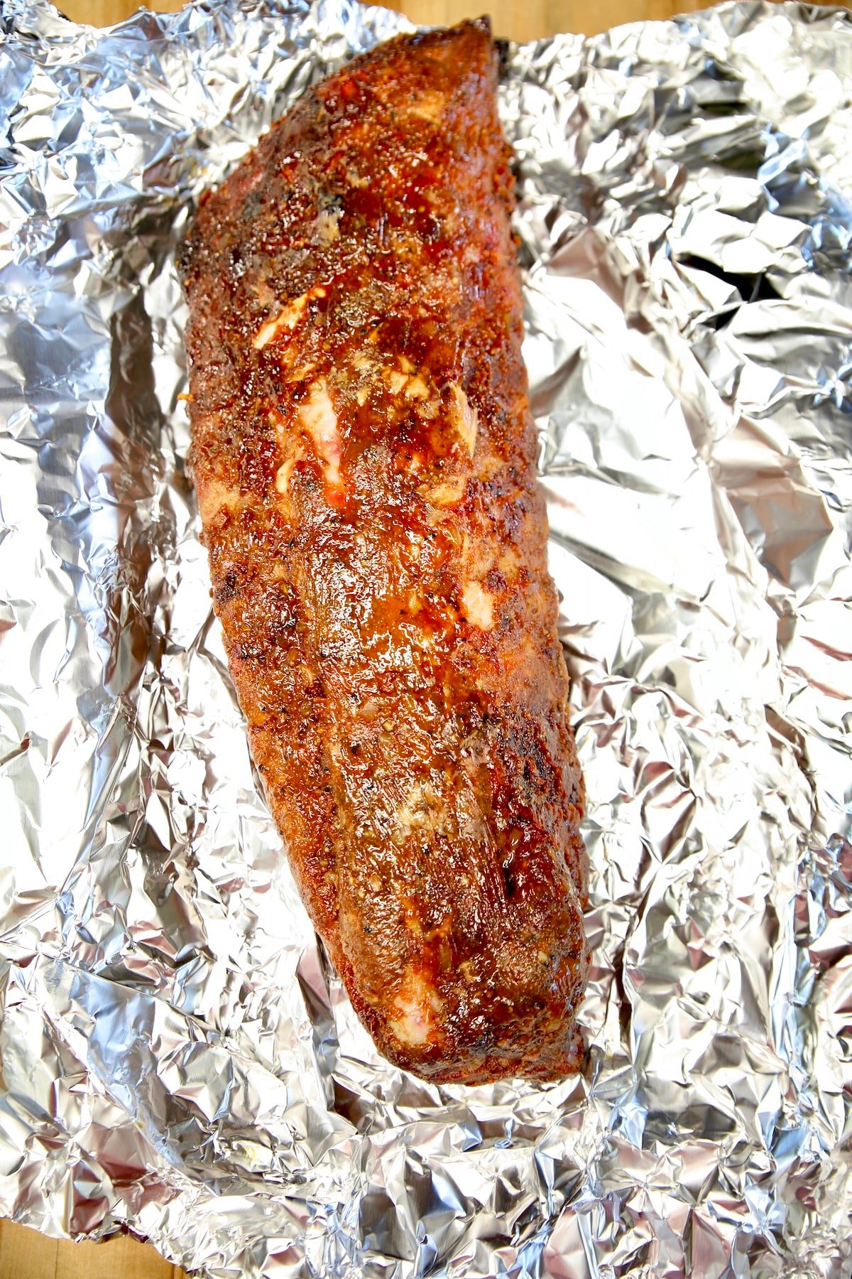 Rack of baby back ribs on foil.