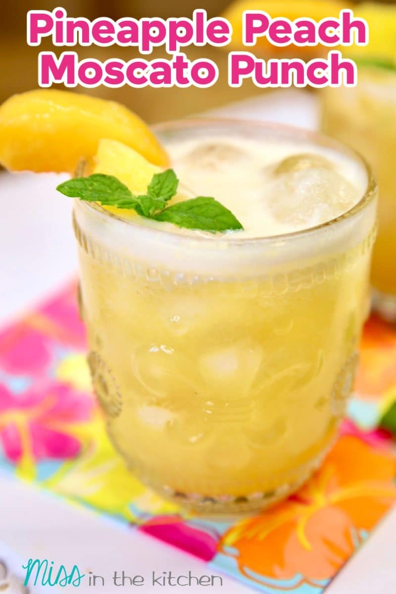 Pineapple Peach Moscato Punch in a glass - text overlay.