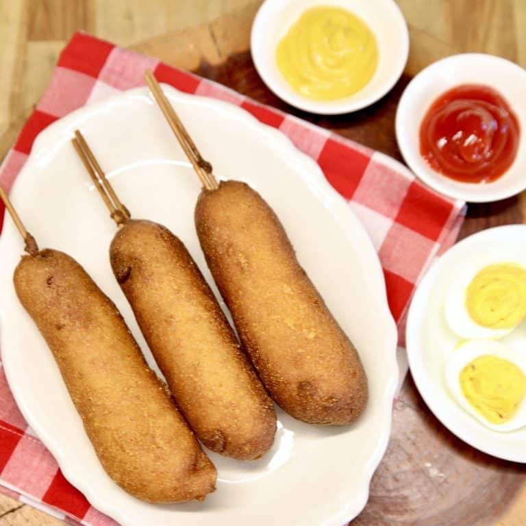 3 Smoked Corn Dogs on a plate with mustard & ketchup.