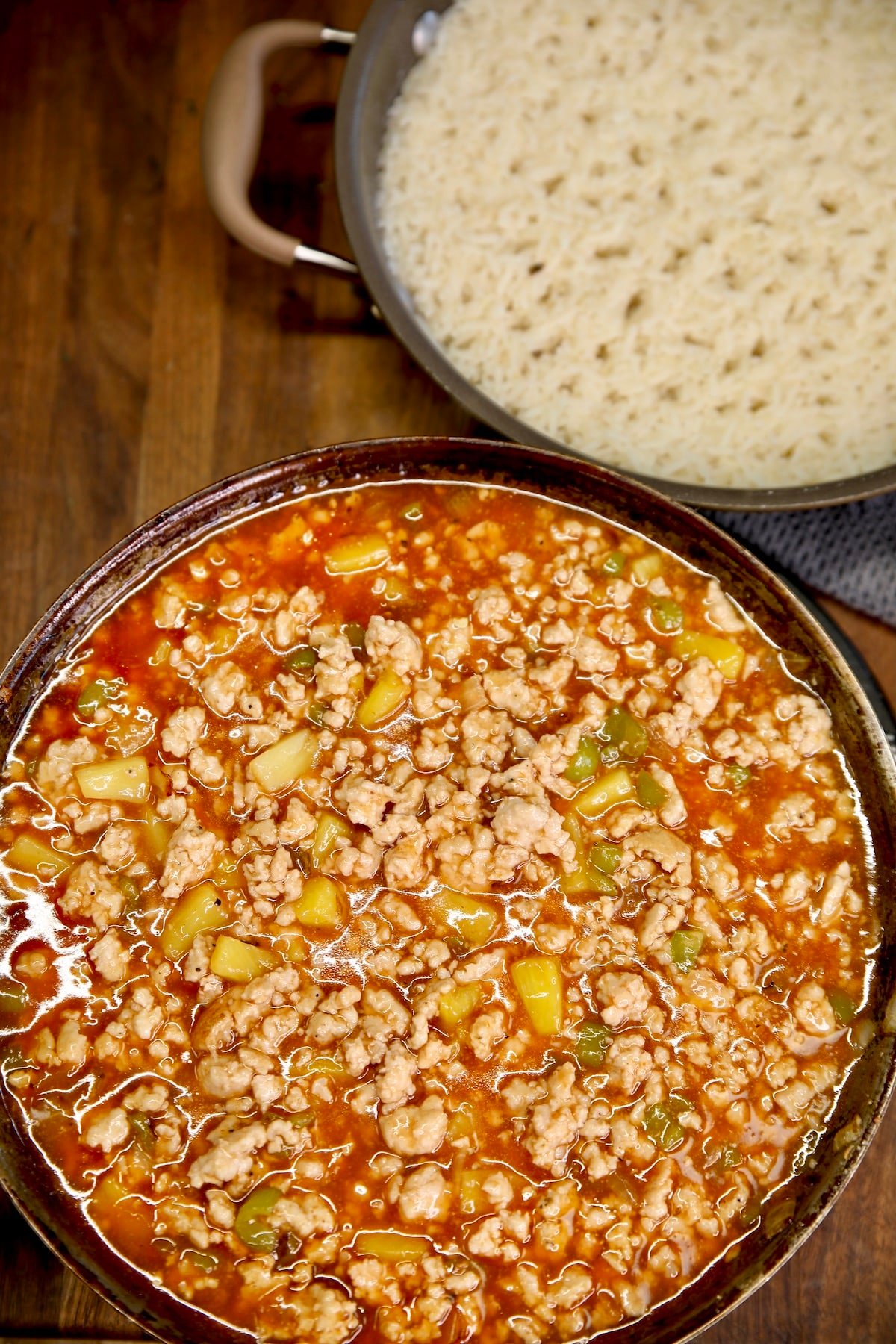Pan of sweet and sour ground pork with pan of rice.