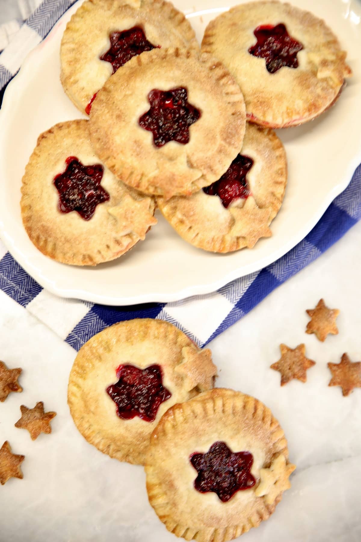 Overhead view of platter of mini pies with blackberry filling.
