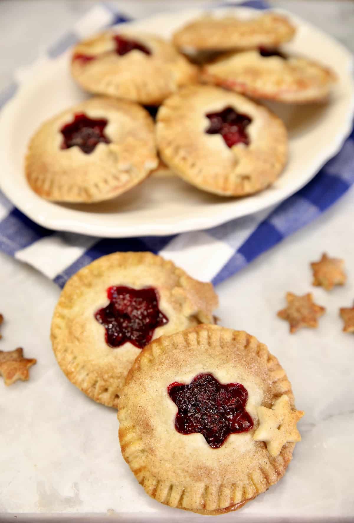 Blackberry hand pies on a platter, 2 in front. 