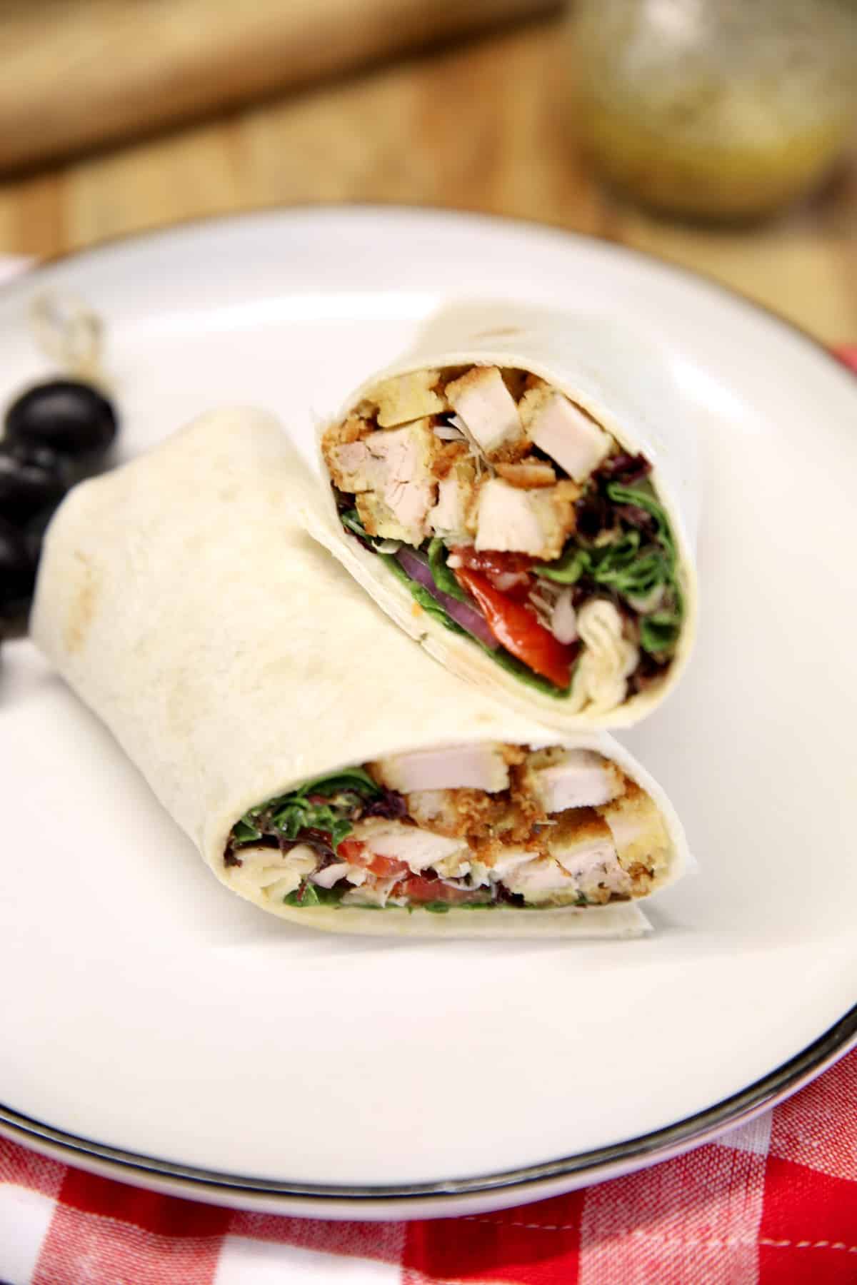 Crispy chicken wrap with tomato, onion, lettuce.