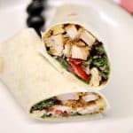 Chicken parmesan wrap cut in half on a plate.