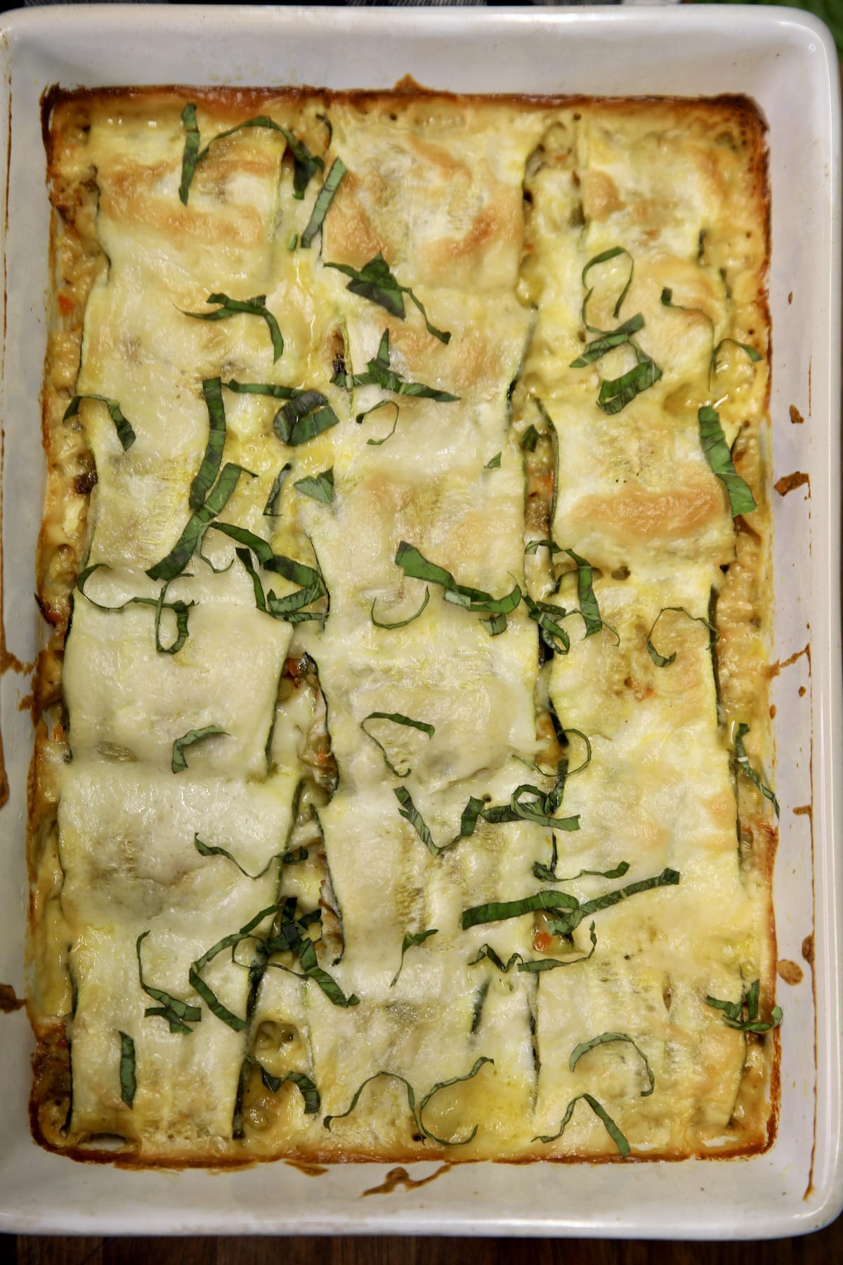 Zucchini casserole garnished with fresh basil.