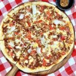 Bacon Cheeseburger Pizza on a pizza peel, red check napkin.