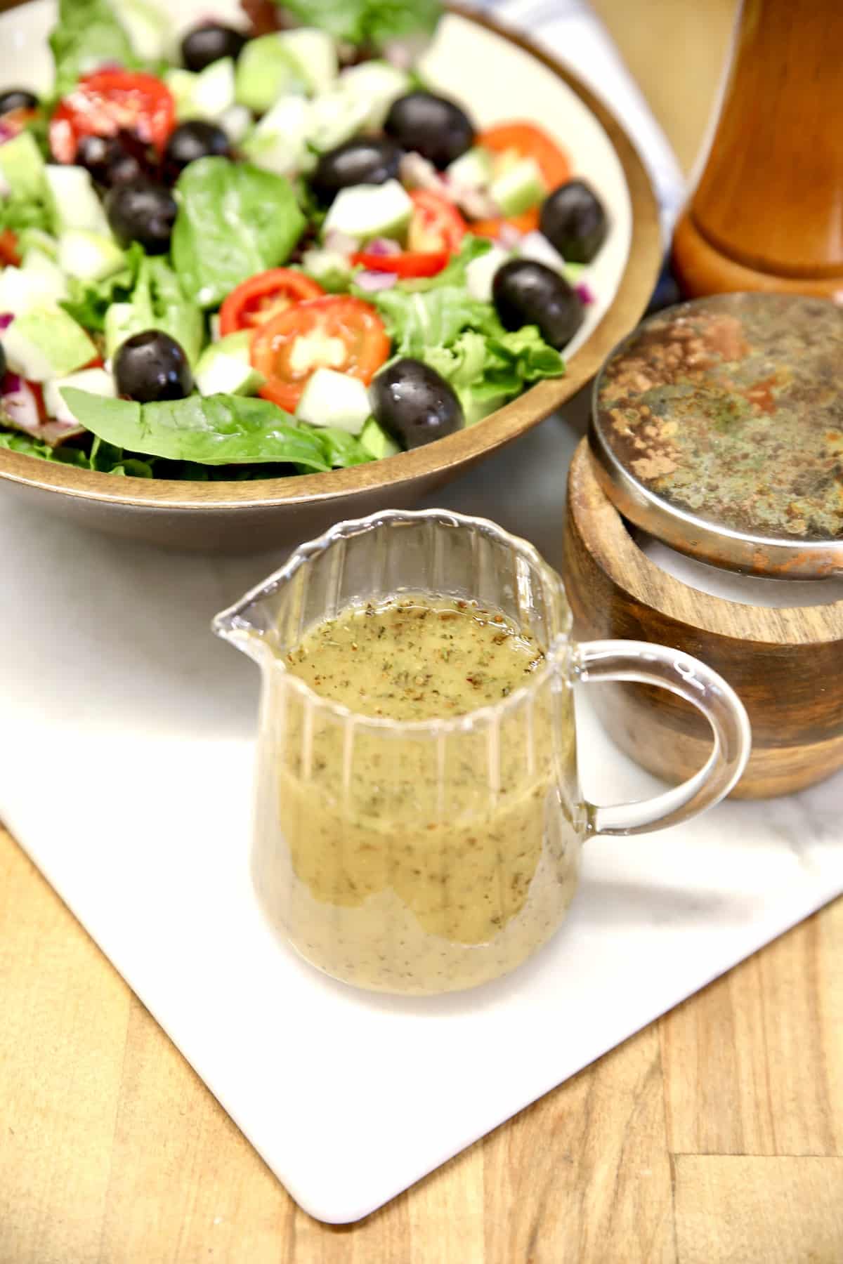 Easy Italian dressing recipe. Salad with pitcher of Italian dressing.