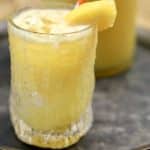 Peach mango wine punch in a glass with peach slice.