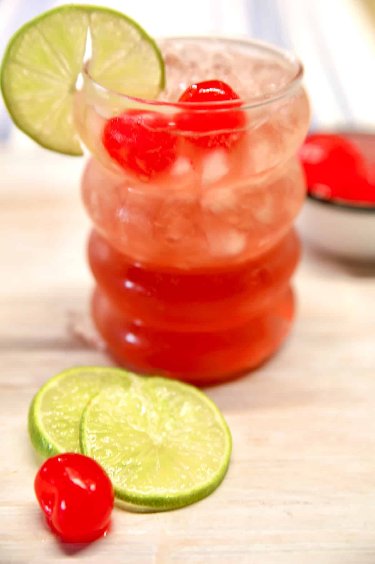 Cherry Limeade Moscato Punch cocktail. Cherry limeade wine punch in a glass with cherry and lime garnish.