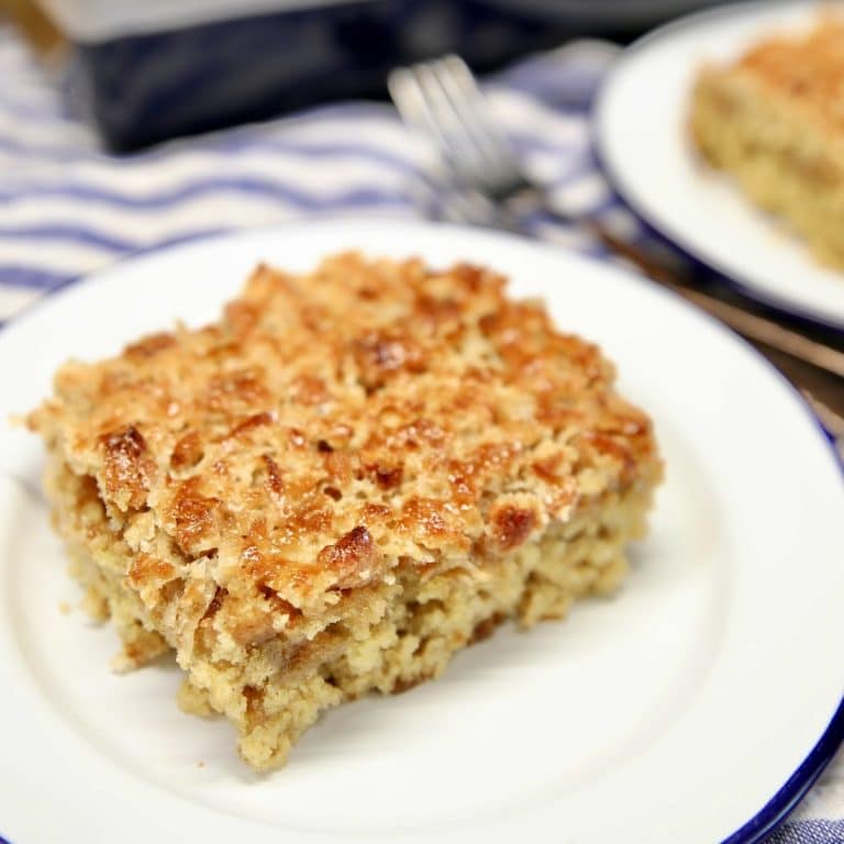 Slice of oatmeal cake with pecan coconut icingn on a plate.