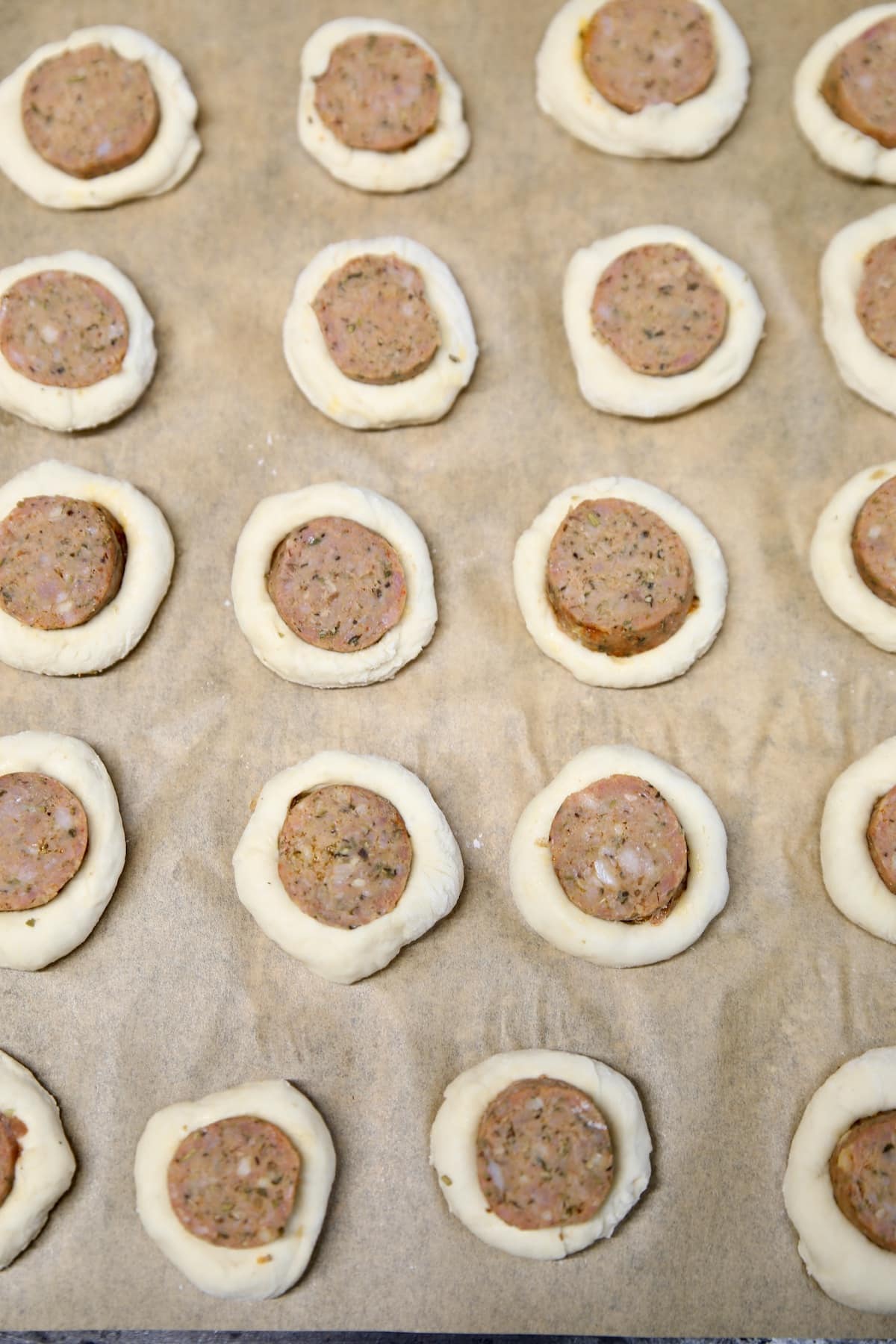 Smoked sausage pizza dough bites on a baking sheet.