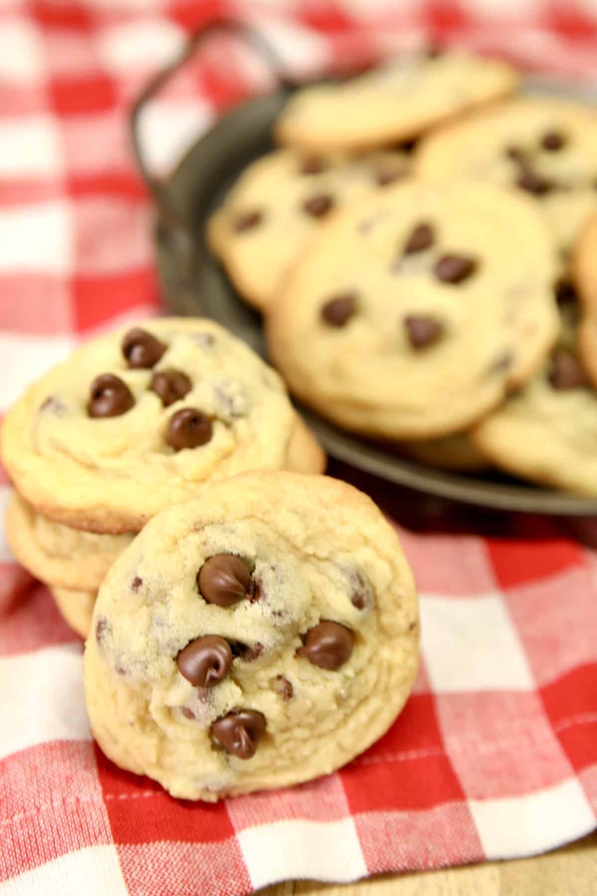 Chocolate chip cookies stacked and on a plate.