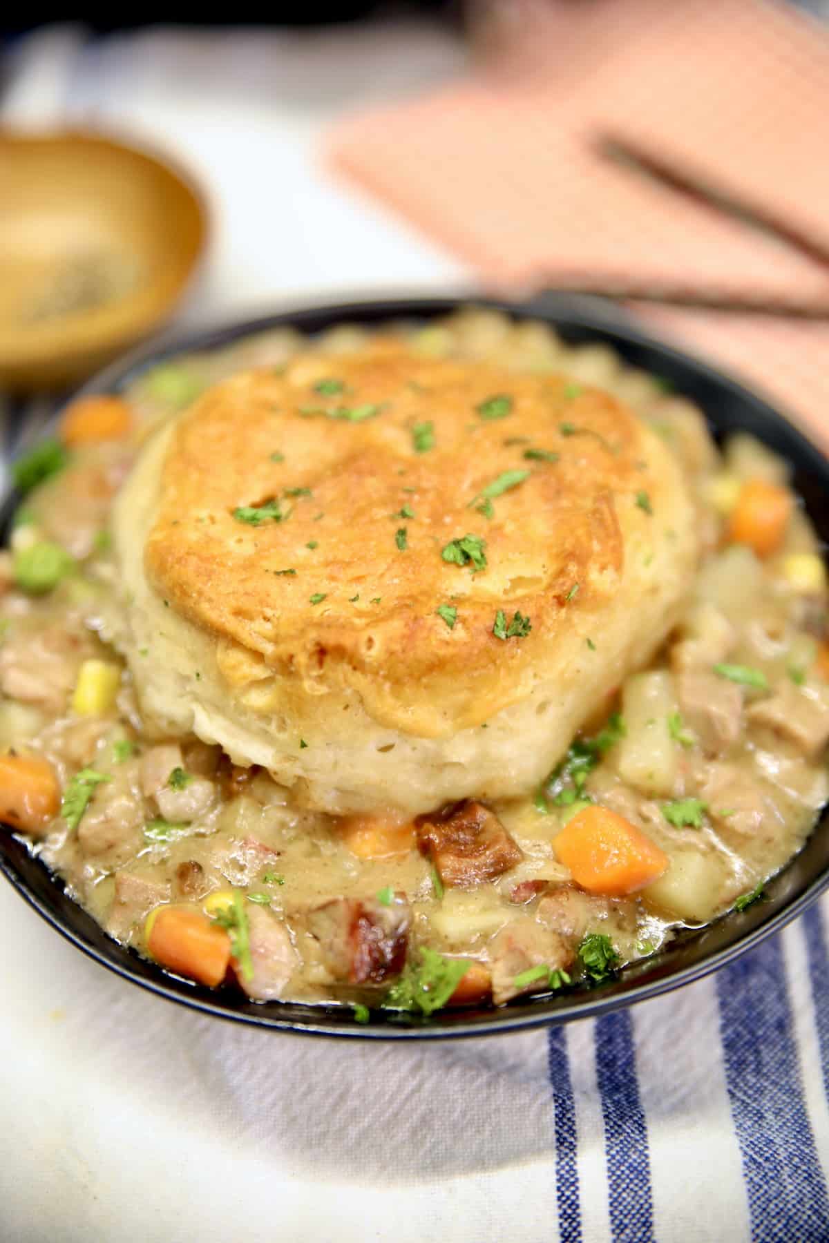 Biscuit topped beef pot pie recipe. Bowl of beef pot pie with biscuit topping.