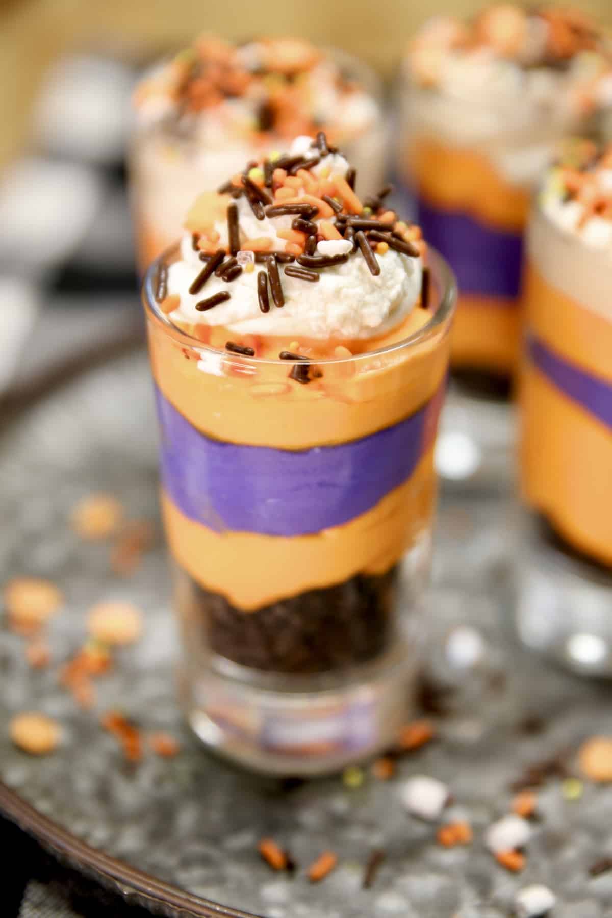No bake cheesecake for Halloween parties. Halloween No Bake Cheesecake with orange and purple layers and Oreo cookies.