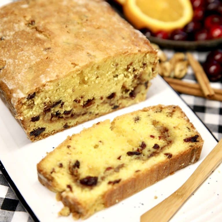 Cranberry orange loaf cake with a slice in front.