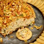 Jalapeno popper cheese ball on a platter with crackers.