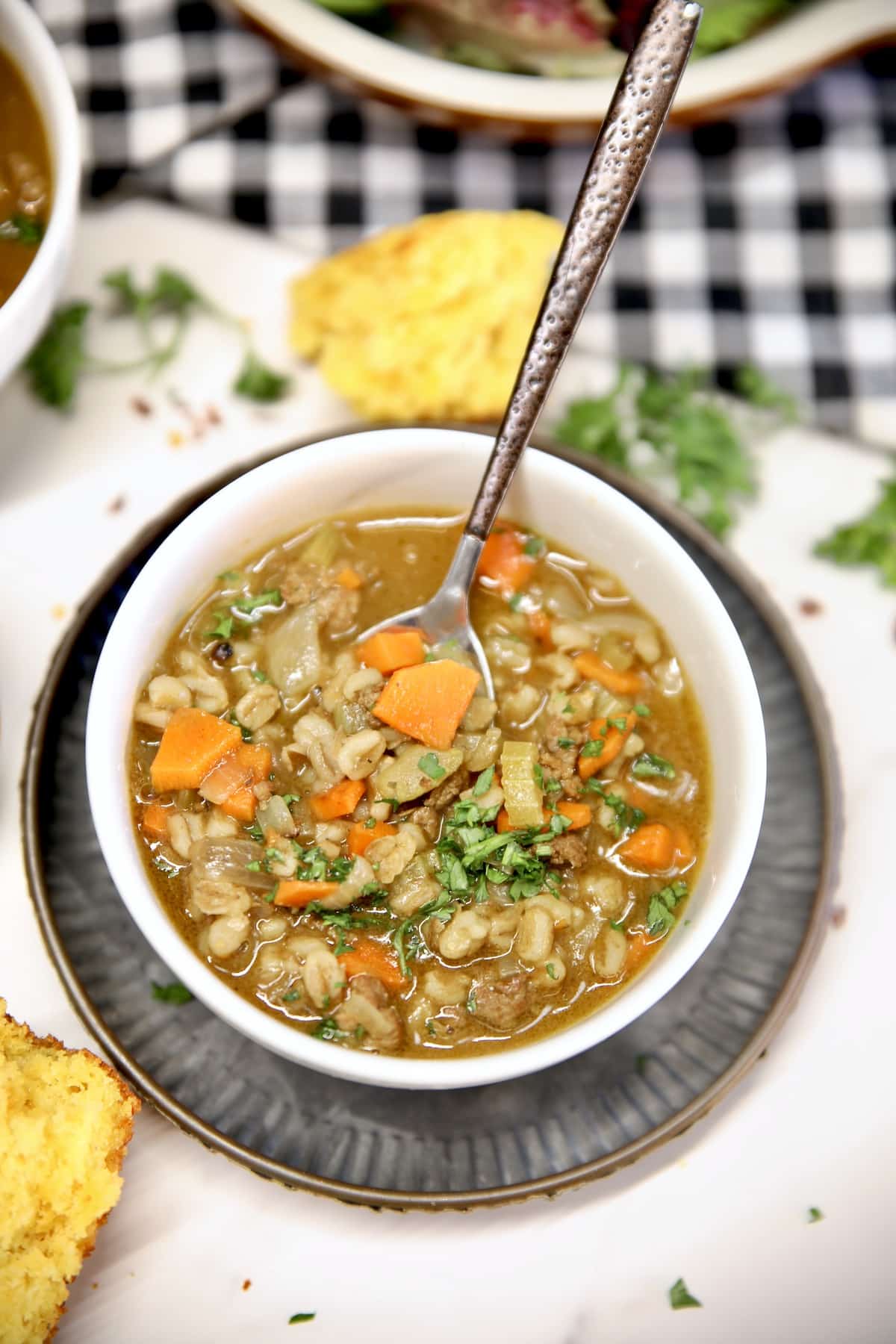 Bowl of beef barley soup with a spoon.