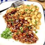 Honey chipotle fried chicken and potatoes on a plate with fork.