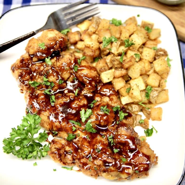 Honey chipotle fried chicken and potatoes on a plate with fork.