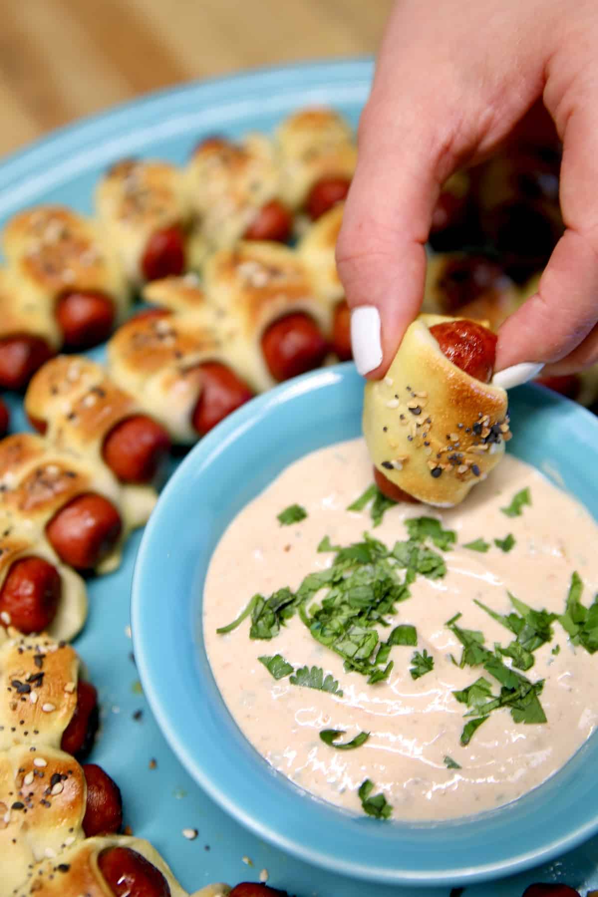 Dipping a Lil Smokies pig in a blanket in sauce.