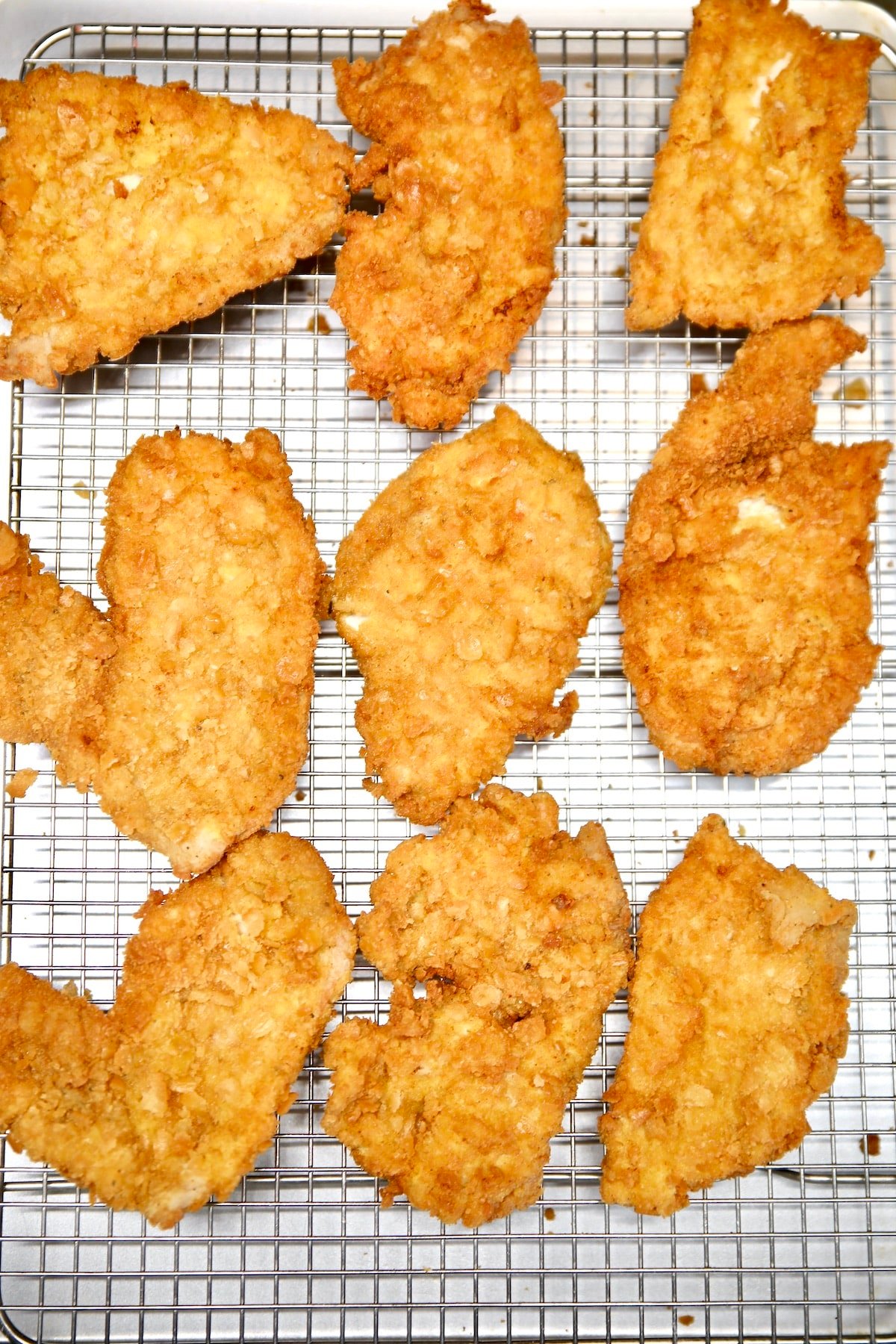 Fried pork cutlets on a wire rack.