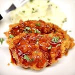 Pork cutlets with honey garlic sauce and mashed potatoes on a plate.
