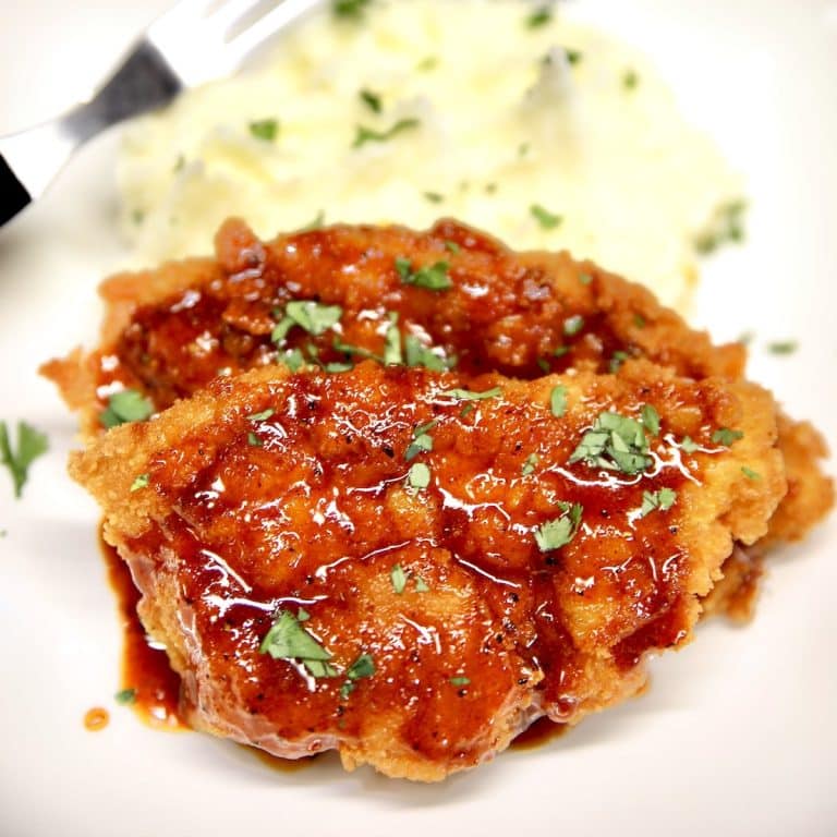 Pork cutlets with honey garlic sauce and mashed potatoes on a plate.