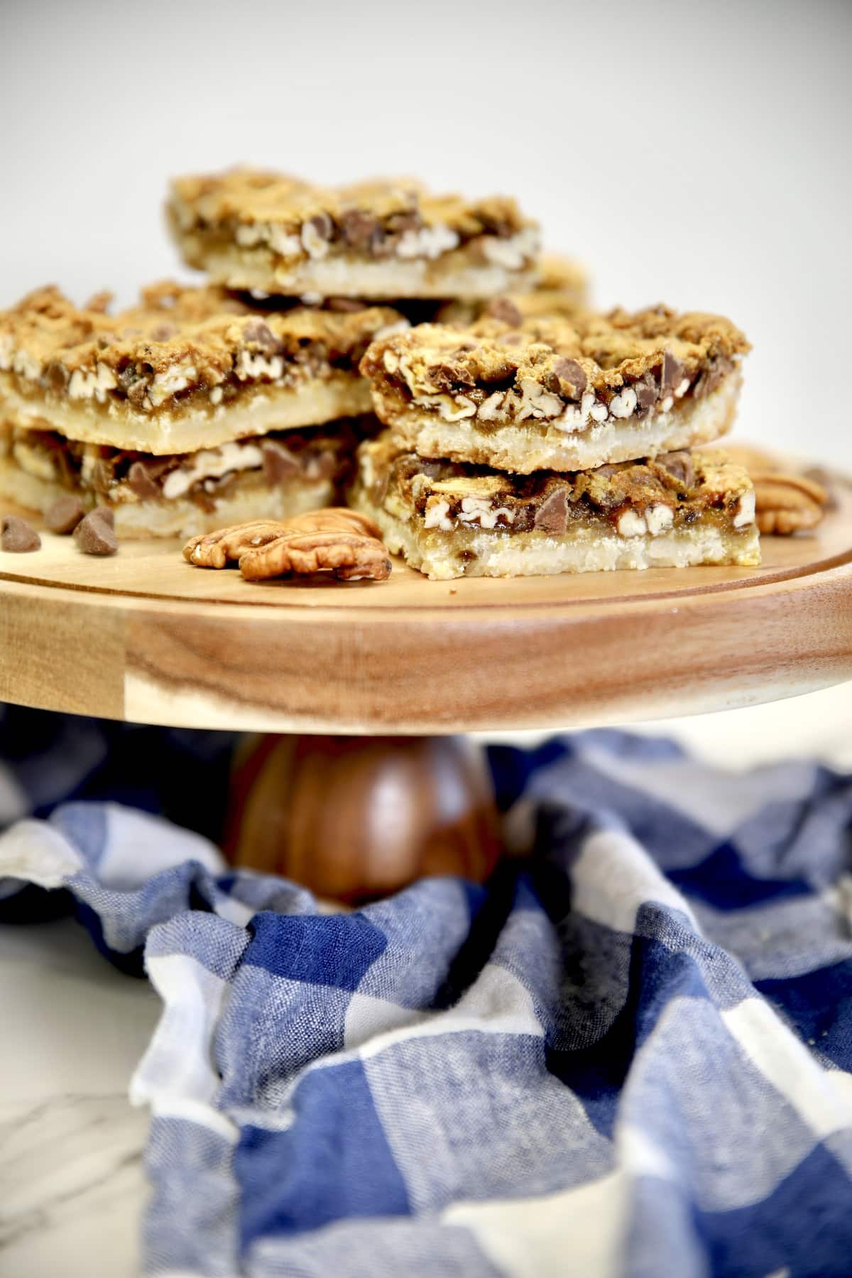 Cake stand with chocolate pecan pie bar slices.