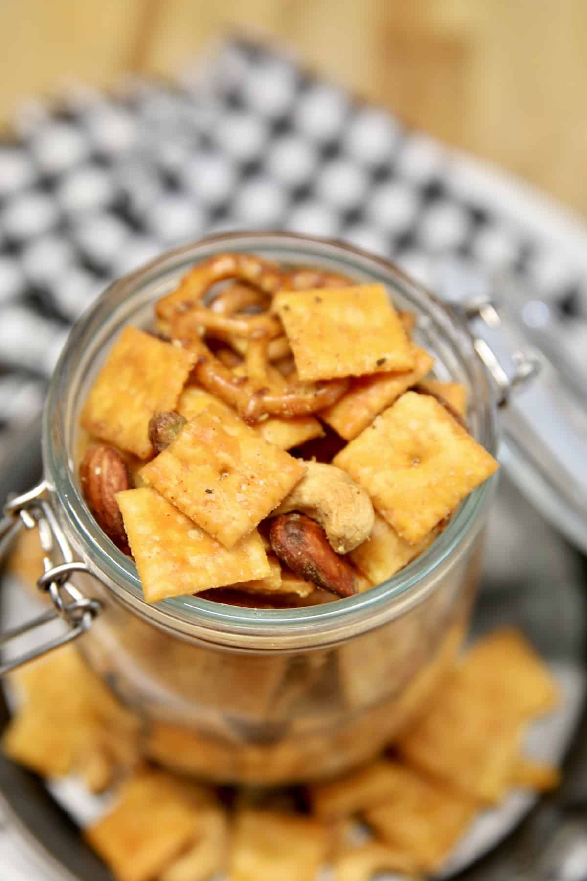 Jar of snack mix on a black and white towel.