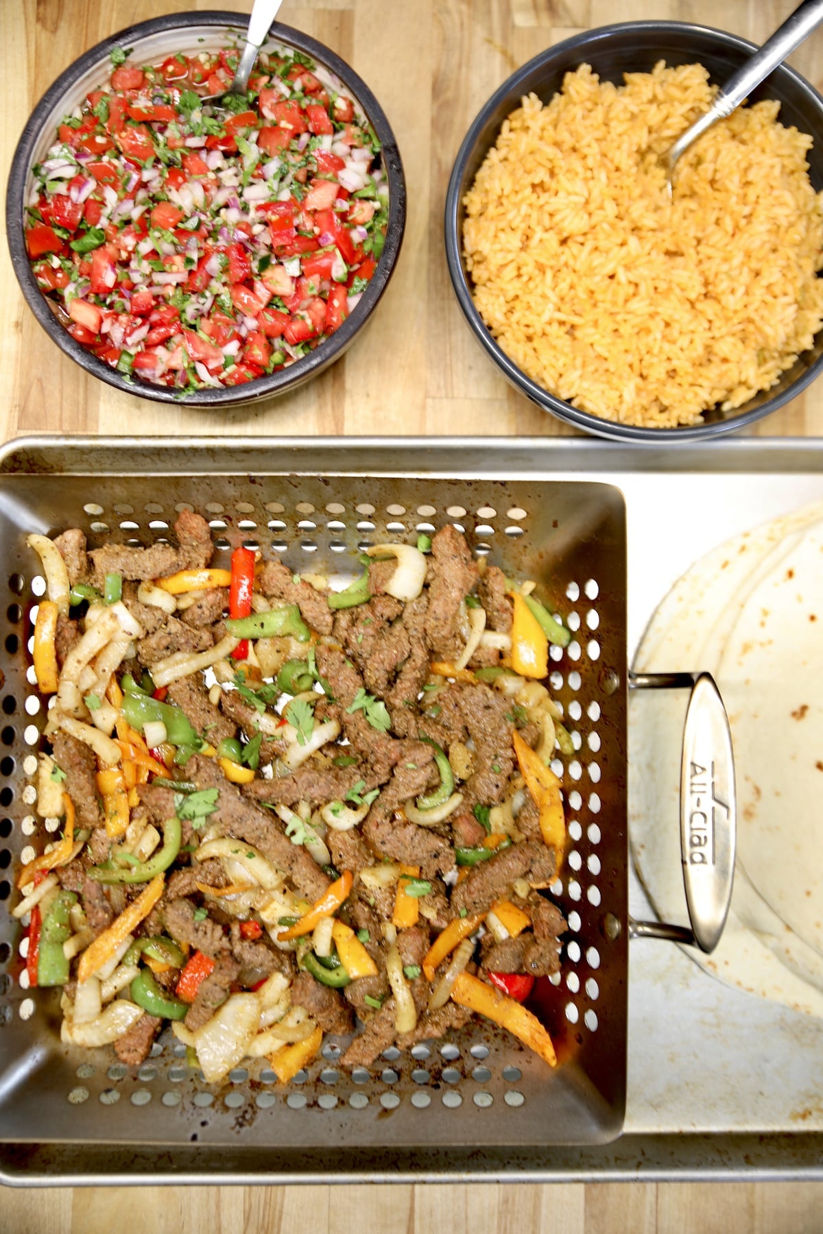Salsa, rice, steak, peppers and onions, tortillas.