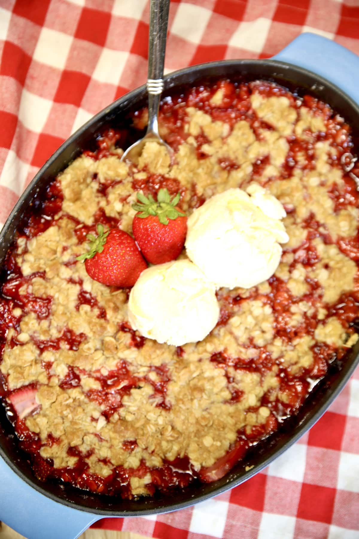Strawberry crisp dessert with vanilla ice cream.