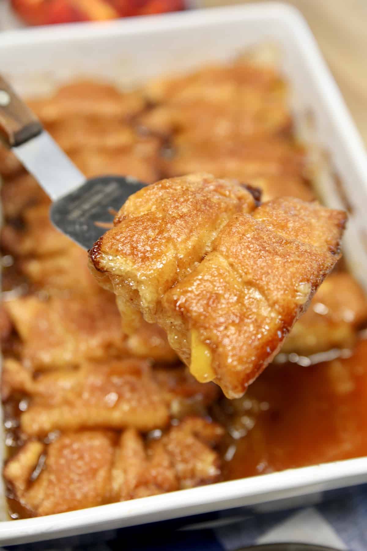 Peach dumplings with crescent dough. Peach dumplings on a spatula.