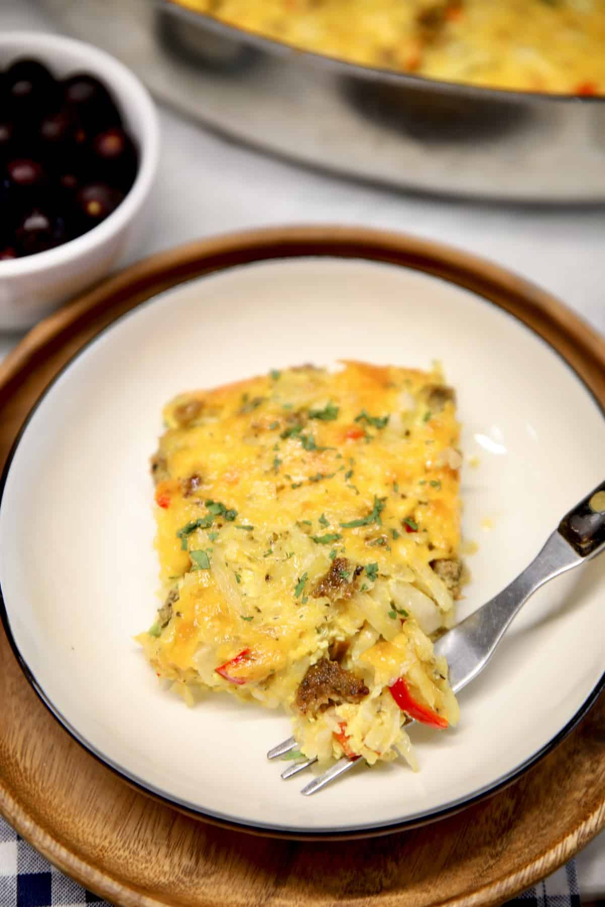 Breakfast casserole with sausage, eggs and cheese. Hashbrown casserole with sausage on a plate.