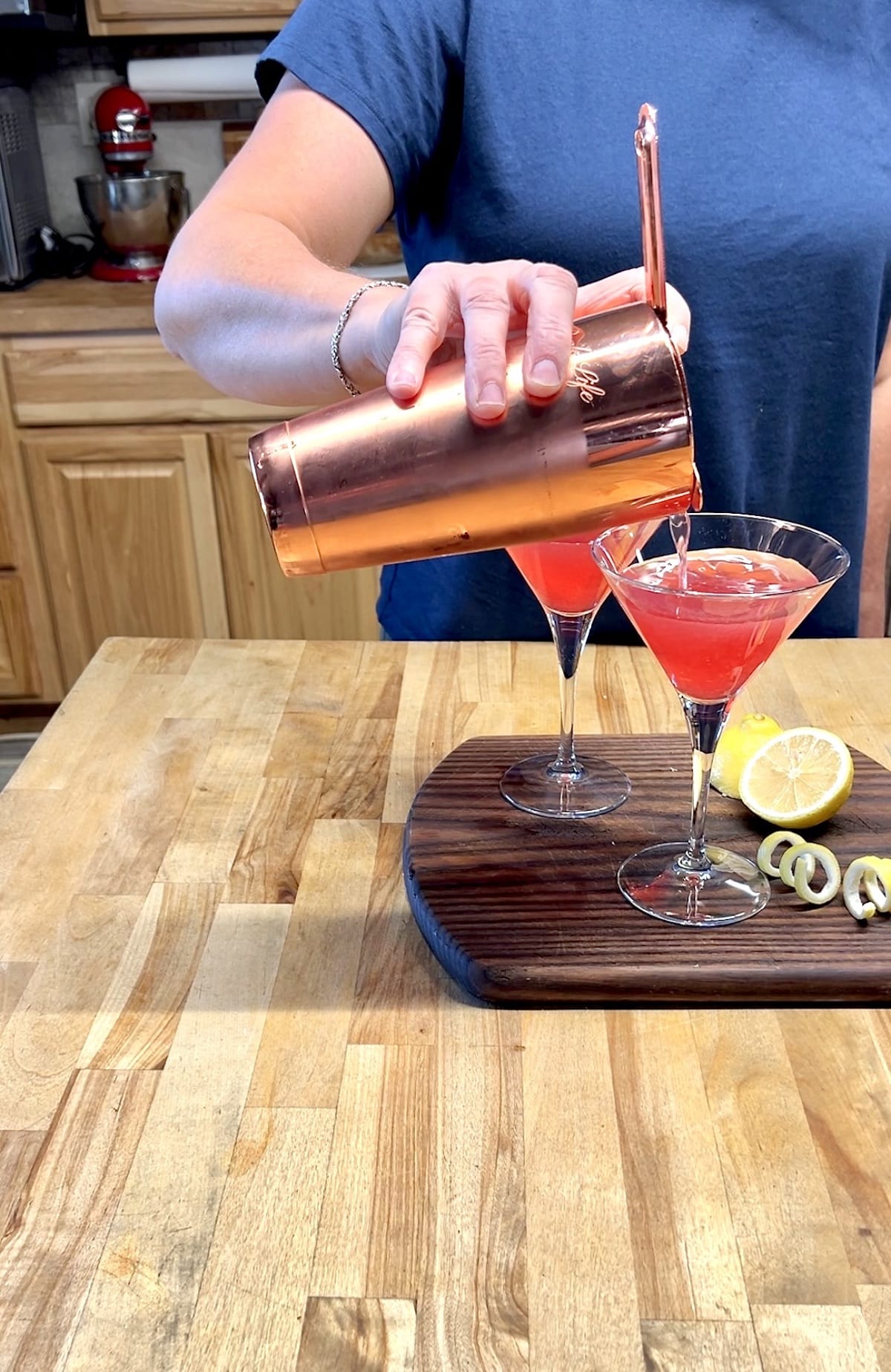Cranberry cocktail straining from shaker to glasses.