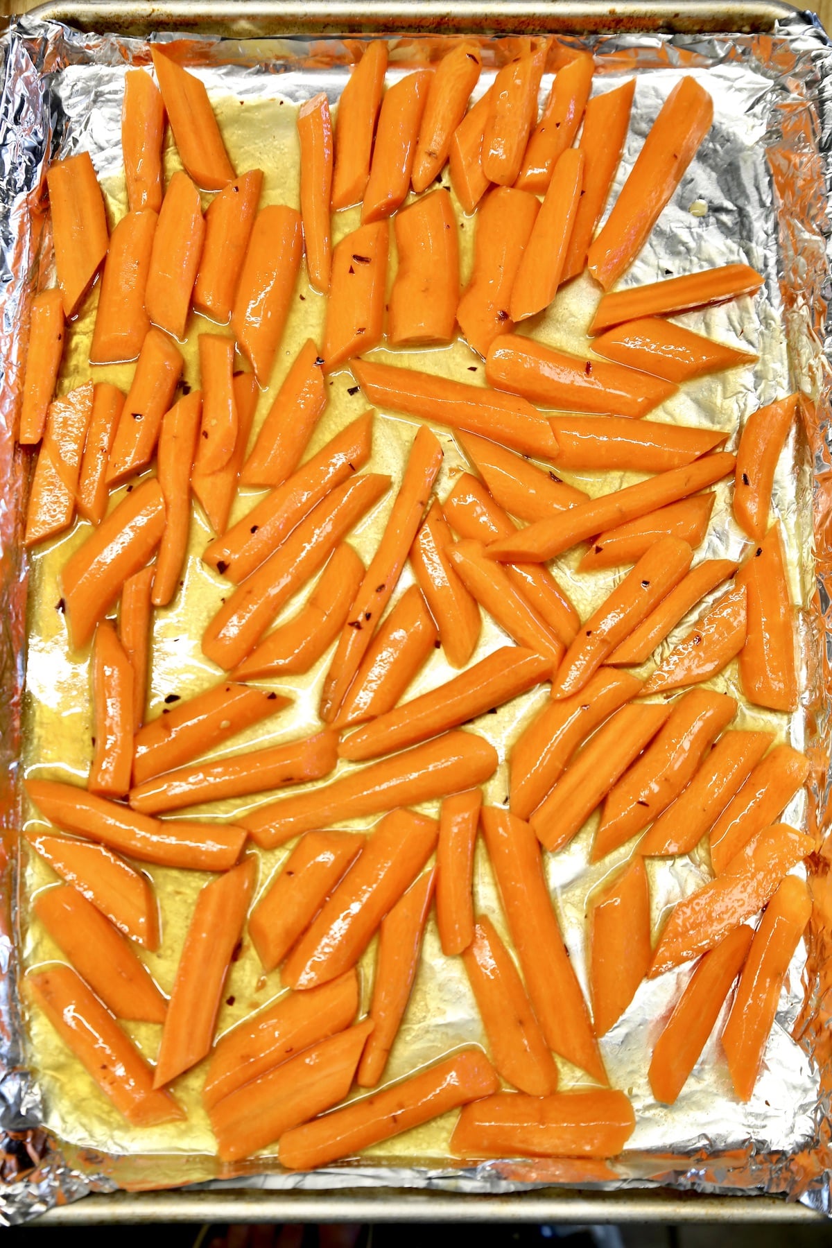 Carrots with butter and maple syrup on a sheet pan.