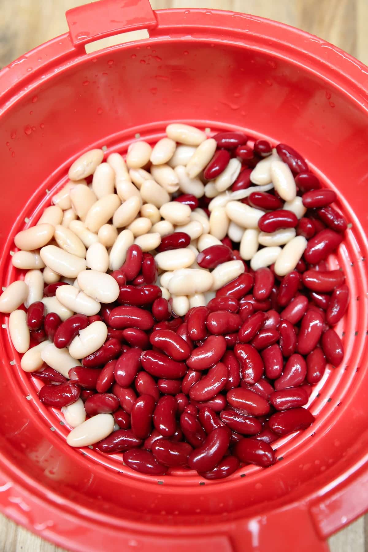 Red strainer with red and white beans.