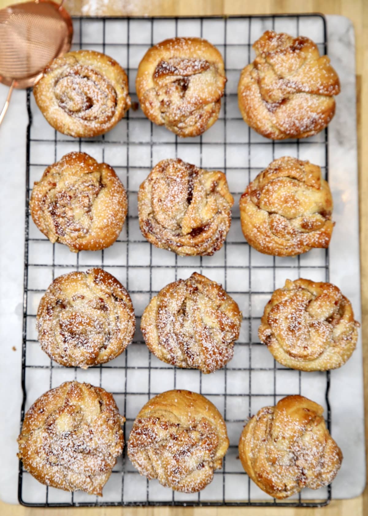 Wire rack with 12 croissant muffins.