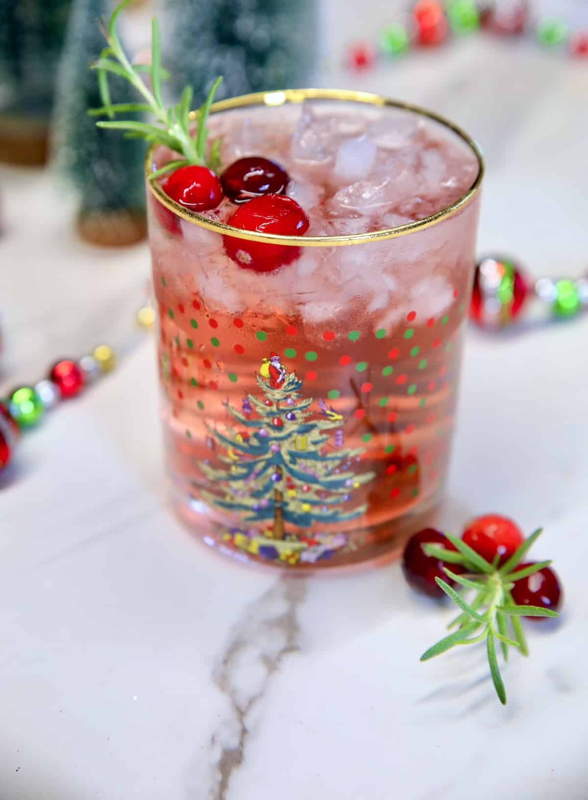 Cranberry cocktail in a glass with cranberries.