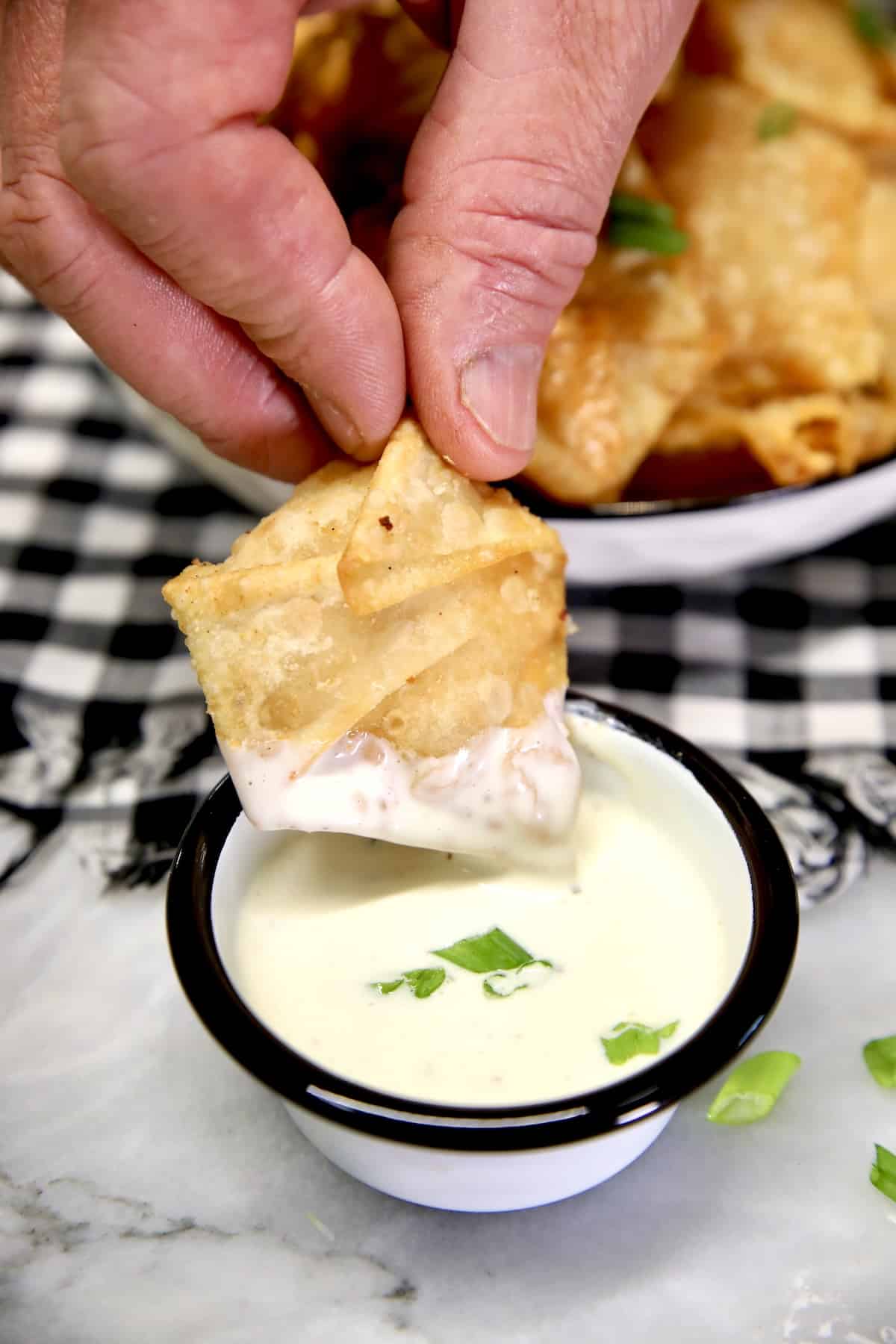 Dipping wonton into ranch dressing.