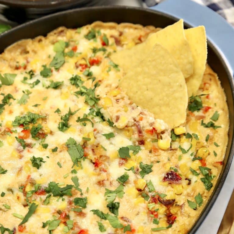 Casserole of corn dip with tortilla chips.