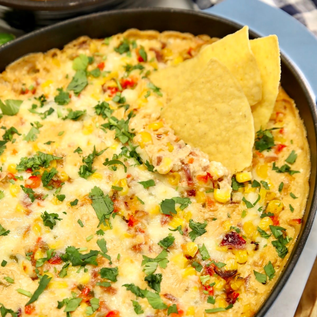 Casserole of corn dip with tortilla chips.