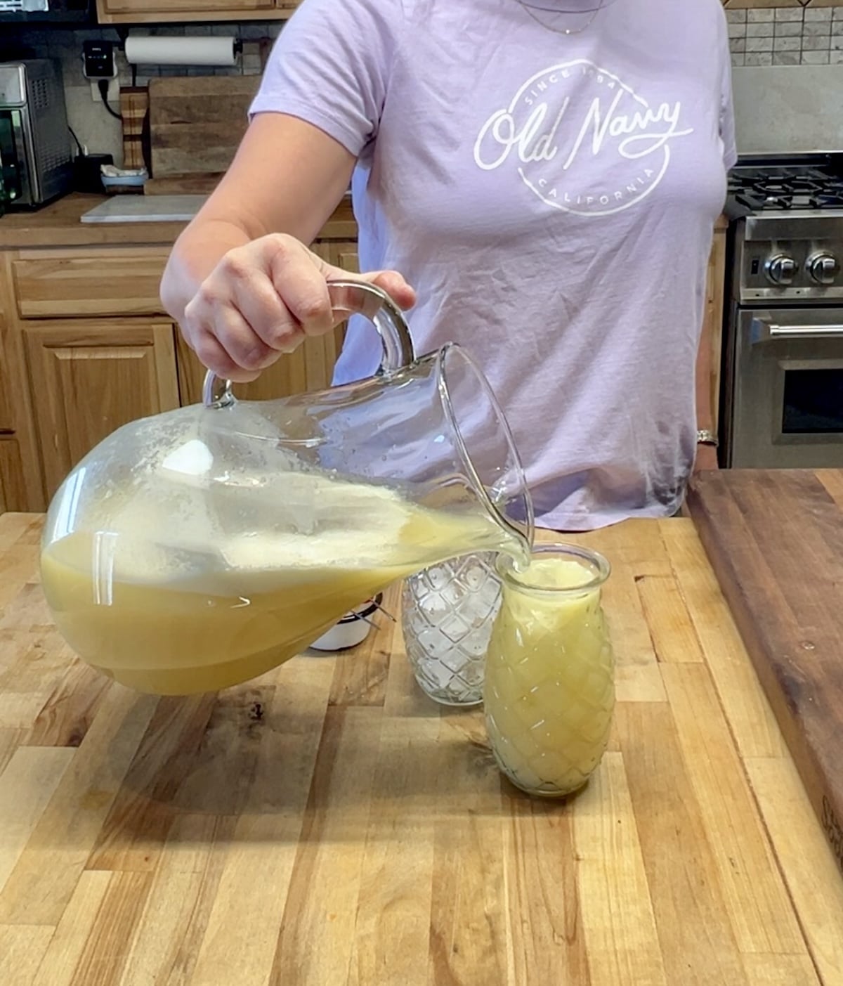 Filling pineapple glasses with punch.
