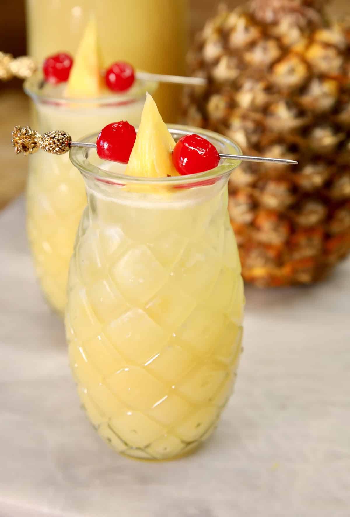 Pineapple coconut punch in glasses with garnish.