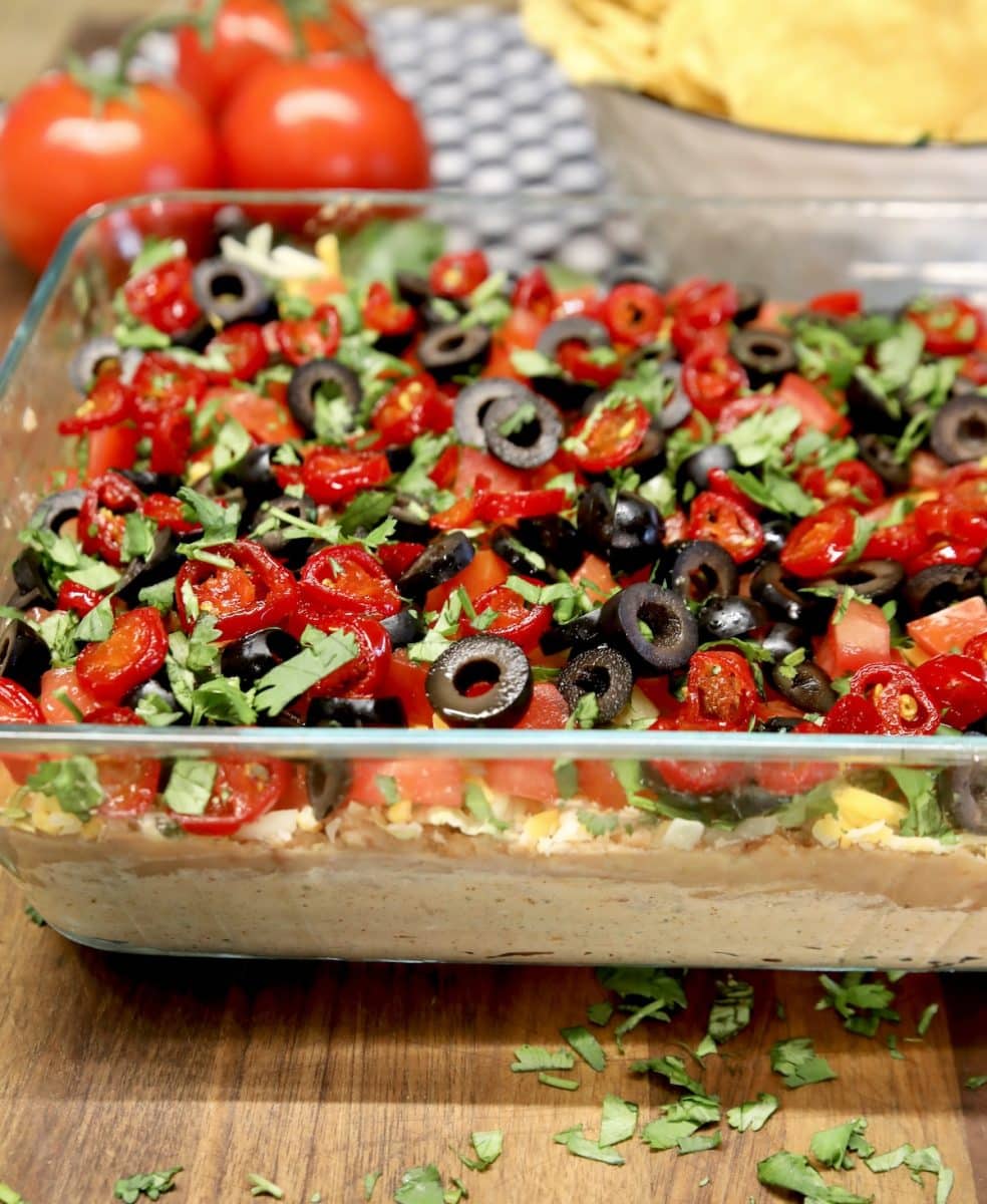 7 layer dip with refried beans, tomatoes and olives.