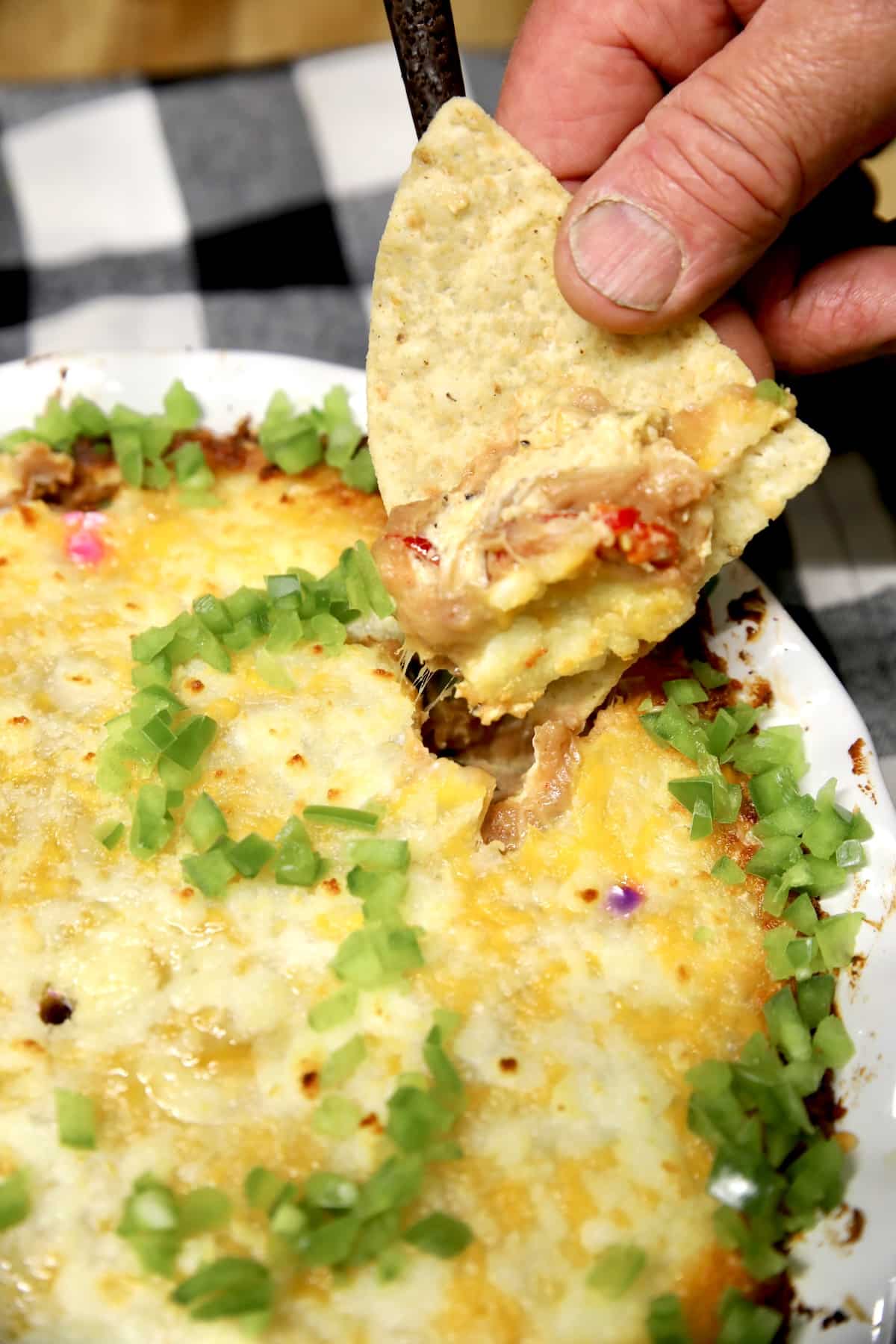 Chip dipping into bean dip.